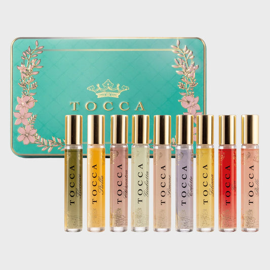 Set of TOCCA perfume bottles in a decorative tin with floral designs.