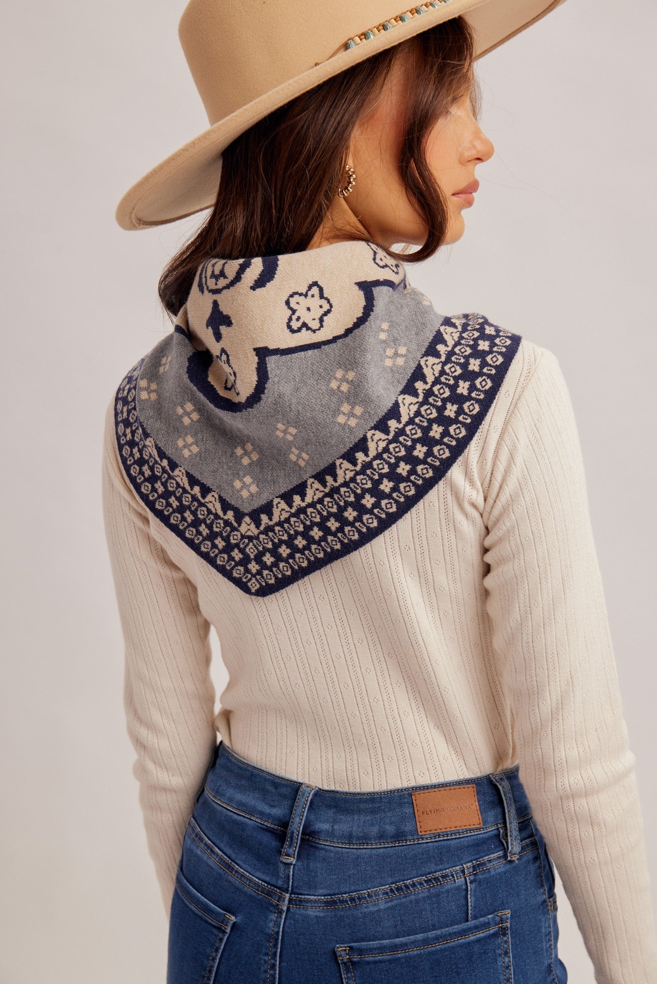 A chic triangle scarf featuring a classic hankie-inspired motif and soft woven blend, perfect for adding an effortless finishing touch to any outfit.
