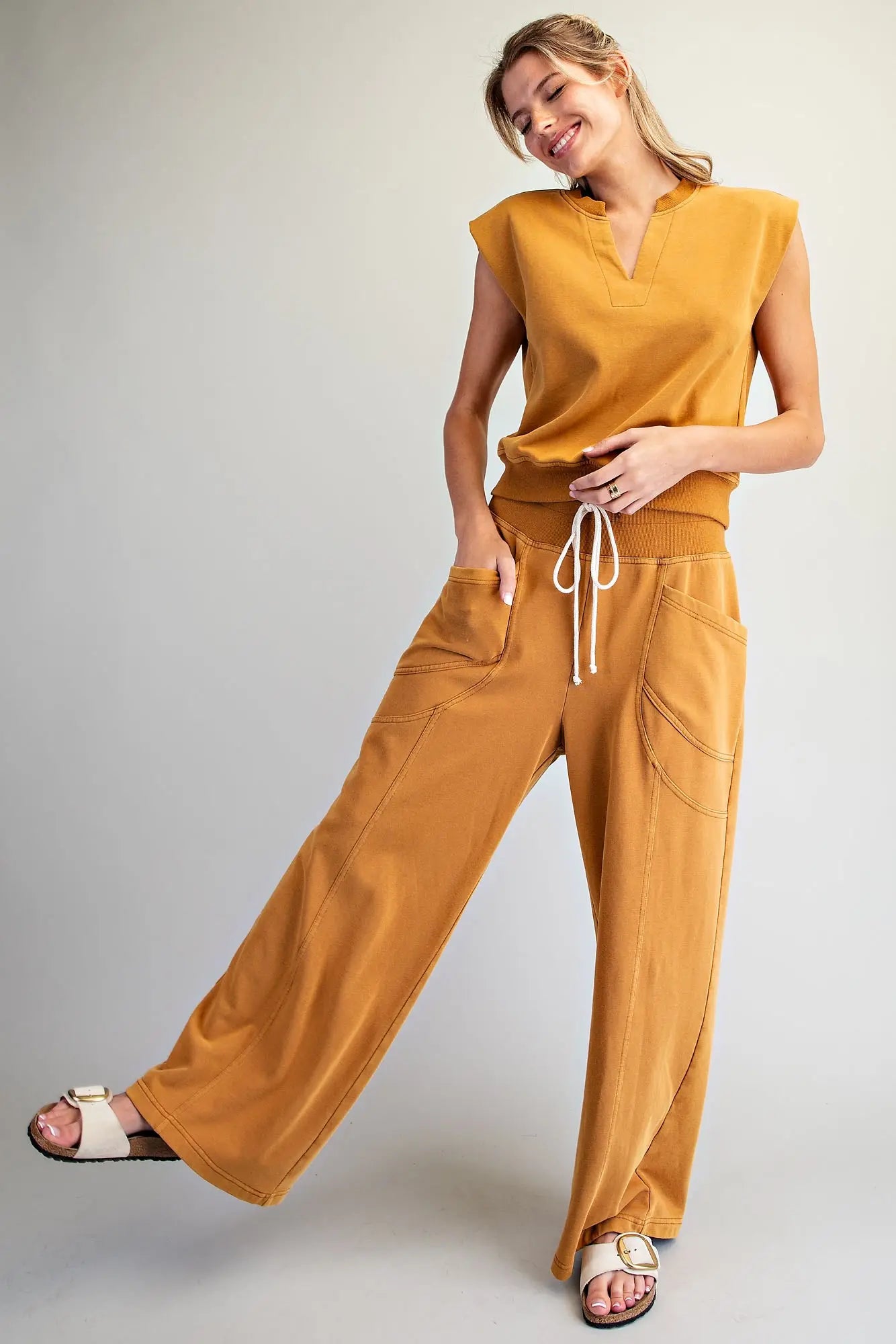 The perfect blend of comfort and style, this relaxed knit lounge set features a notched neck cap sleeve top and wide leg pants.