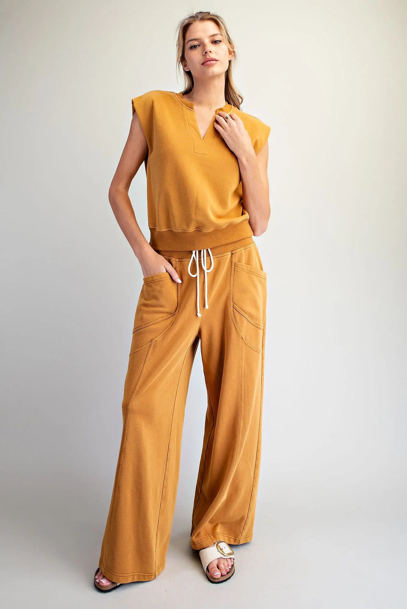 The perfect blend of comfort and style, this relaxed knit lounge set features a notched neck cap sleeve top and wide leg pants.