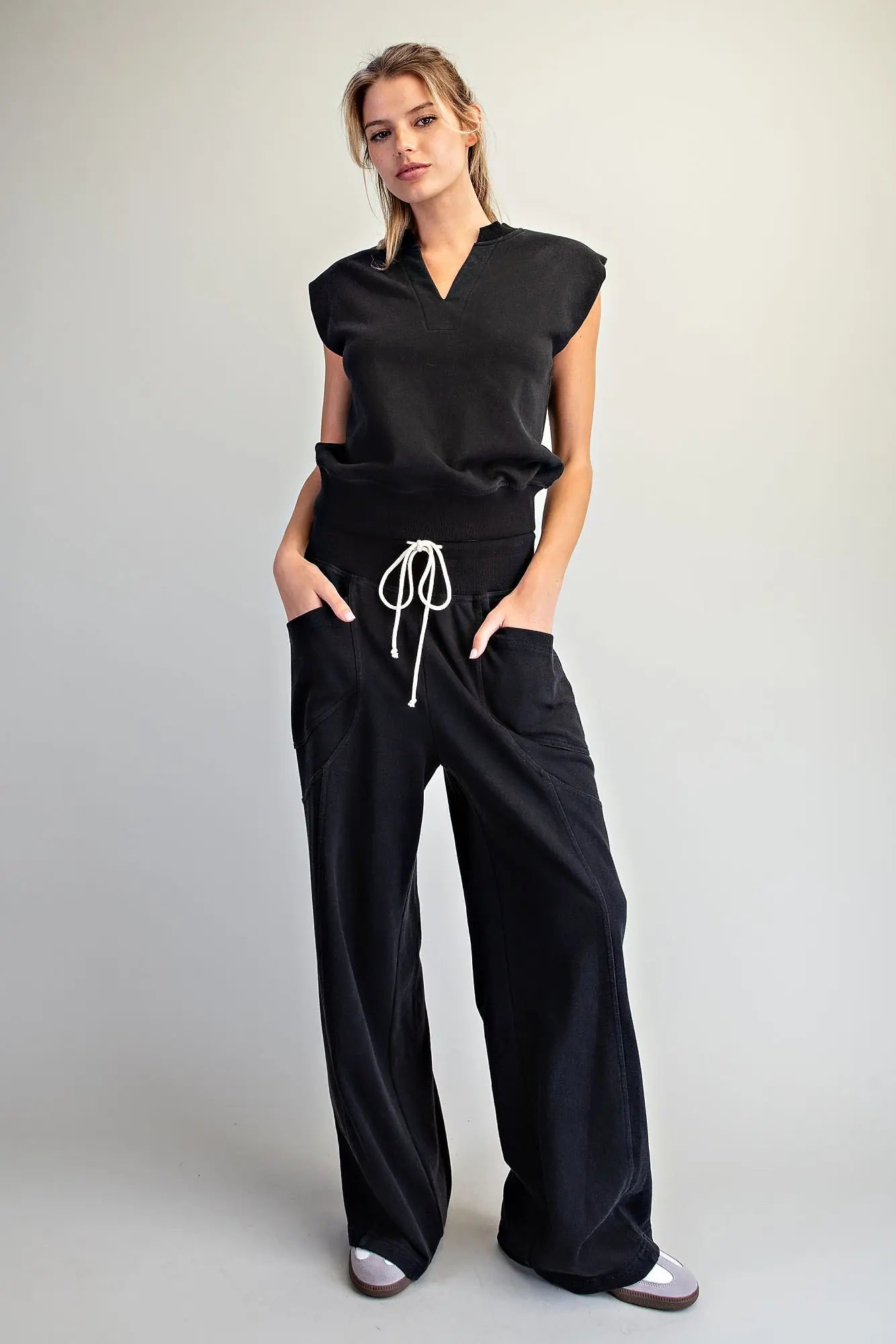 The perfect blend of comfort and style, this relaxed knit lounge set features a notched neck cap sleeve top and wide leg pants.