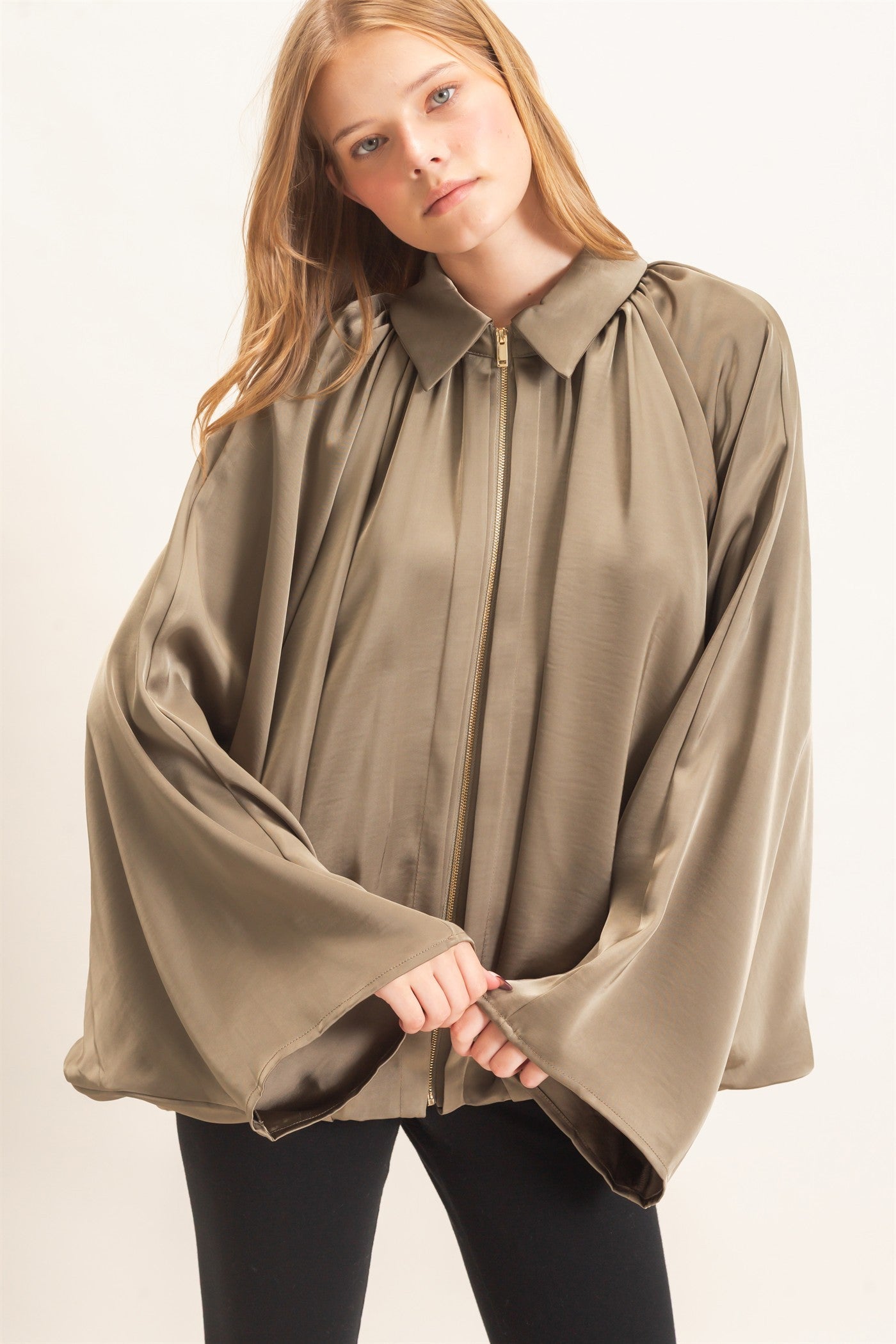 A chic satin jacket with a voluminous balloon silhouette, polished collar, and concealed zipper for an effortlessly elevated finish.