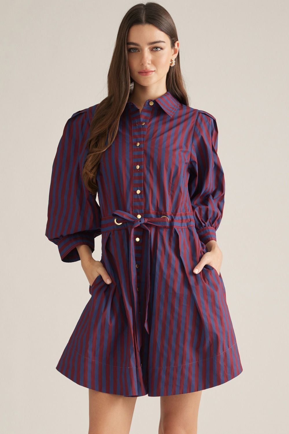 A polished striped mini dress featuring 3/4 puff sleeves, a button-front closure, and a self-tie waist belt with a chic metal ring accent.